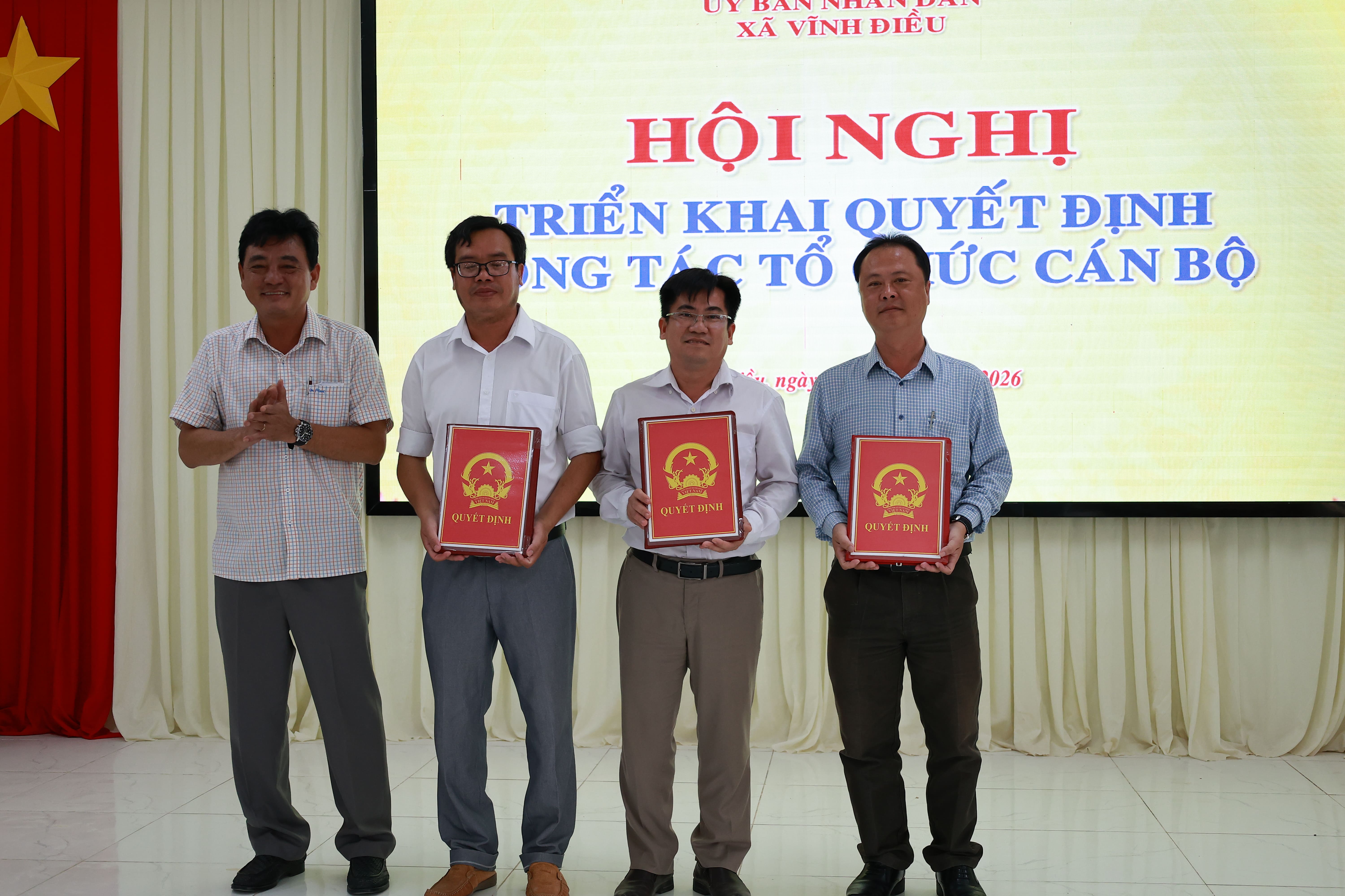 Ông Hà Quang Minh - Chủ tịch UBND xã (Bên trái) trao quyết định công tác cán bộ